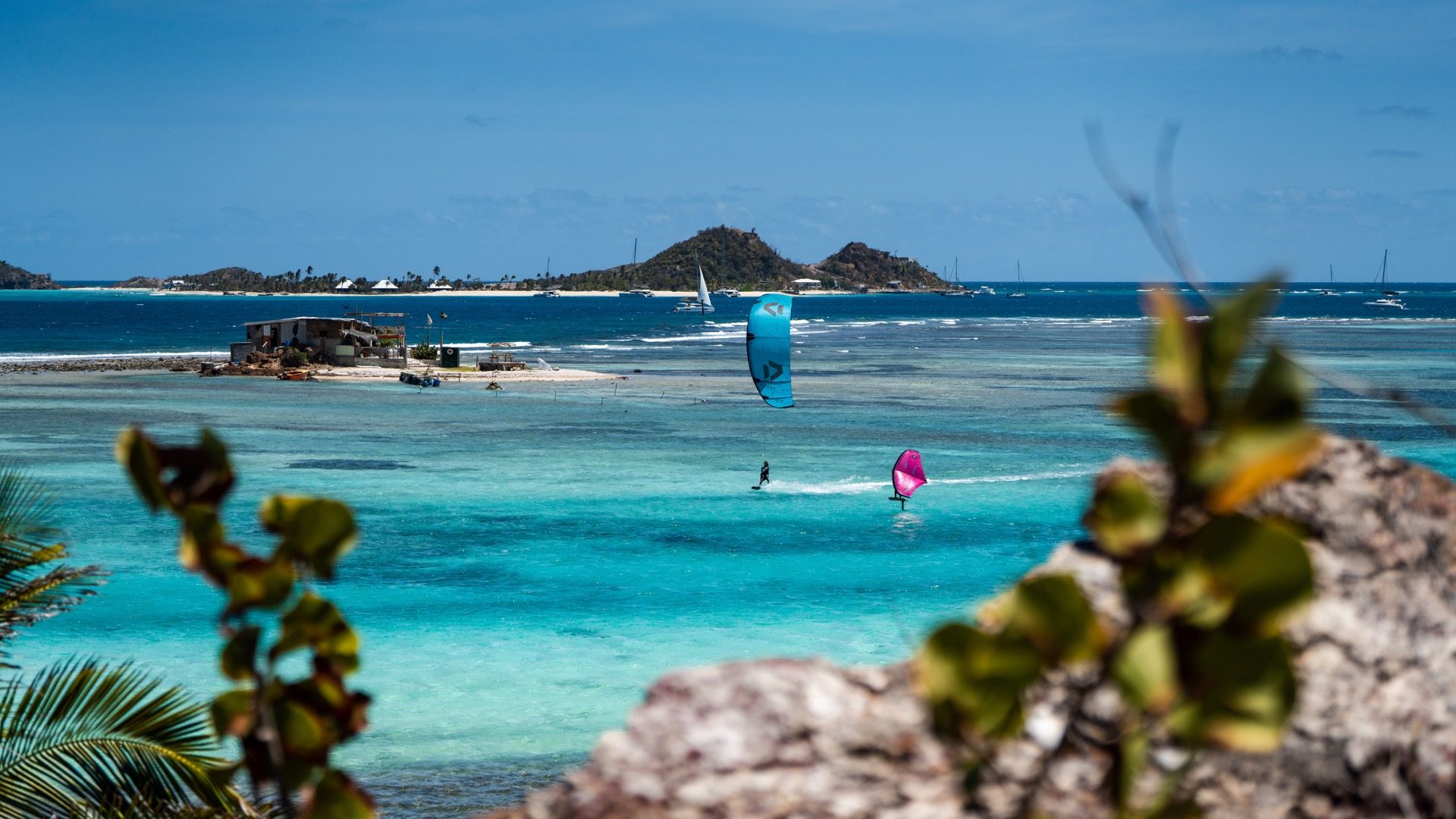Kitesurfing and wing foiling on turquoise water off Union Island