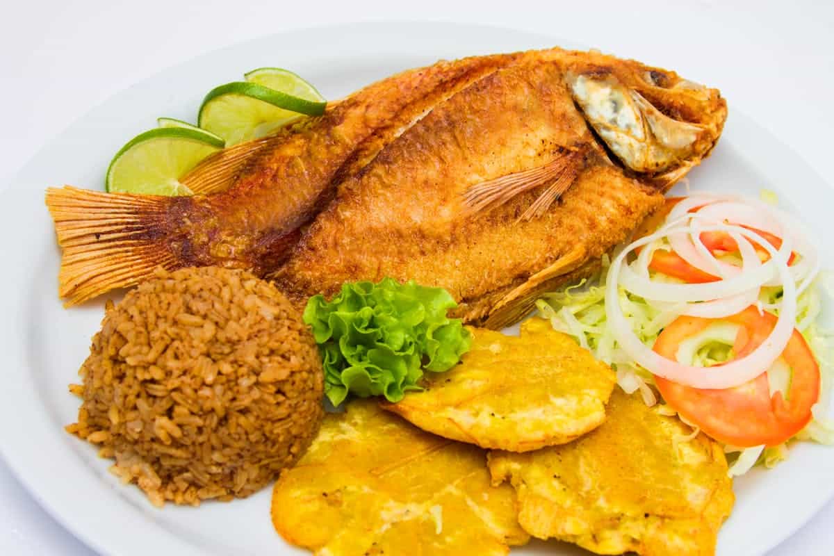 Fried fish with rice and salad local Caribbean food plate
