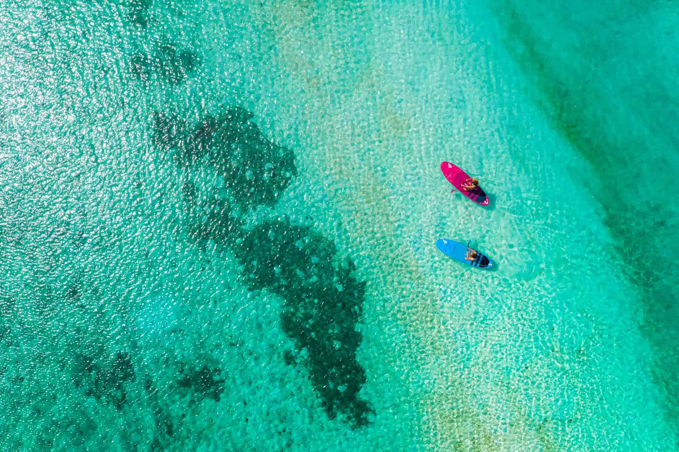 Paddleboarding through turquoise water on Union Island