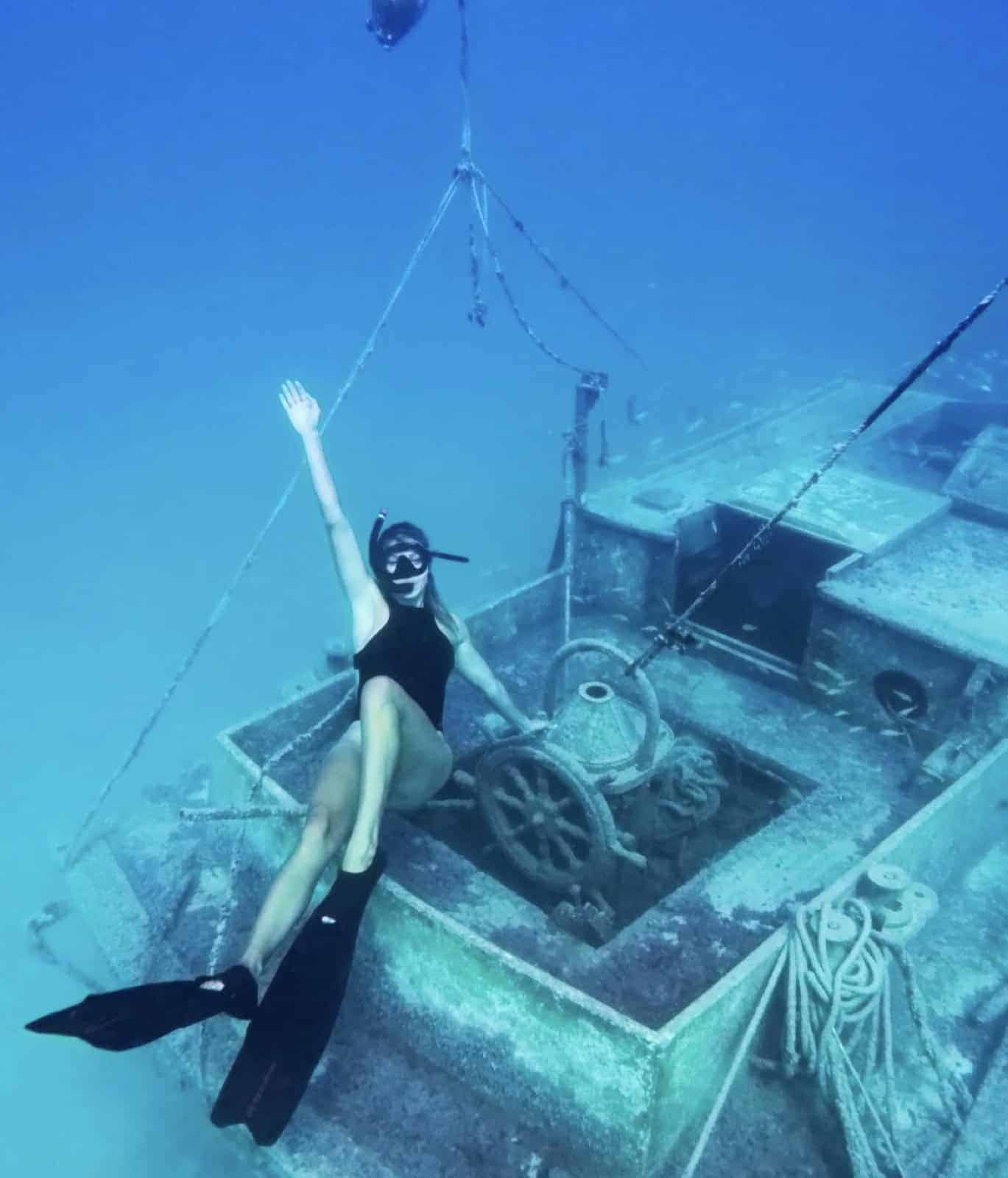 Snorkeler exploring a shallow shipwreck without dive tanks