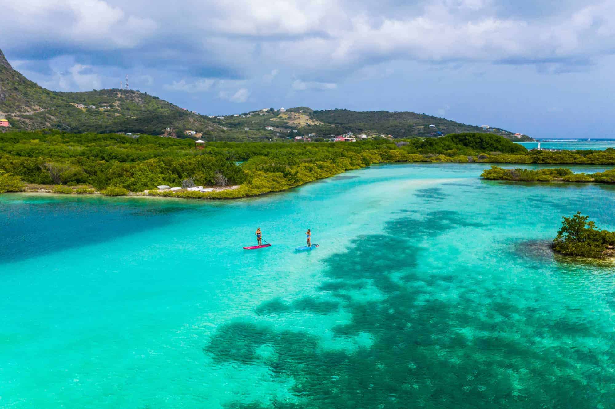 Drone view of stand up paddle boards in clear Union Island water