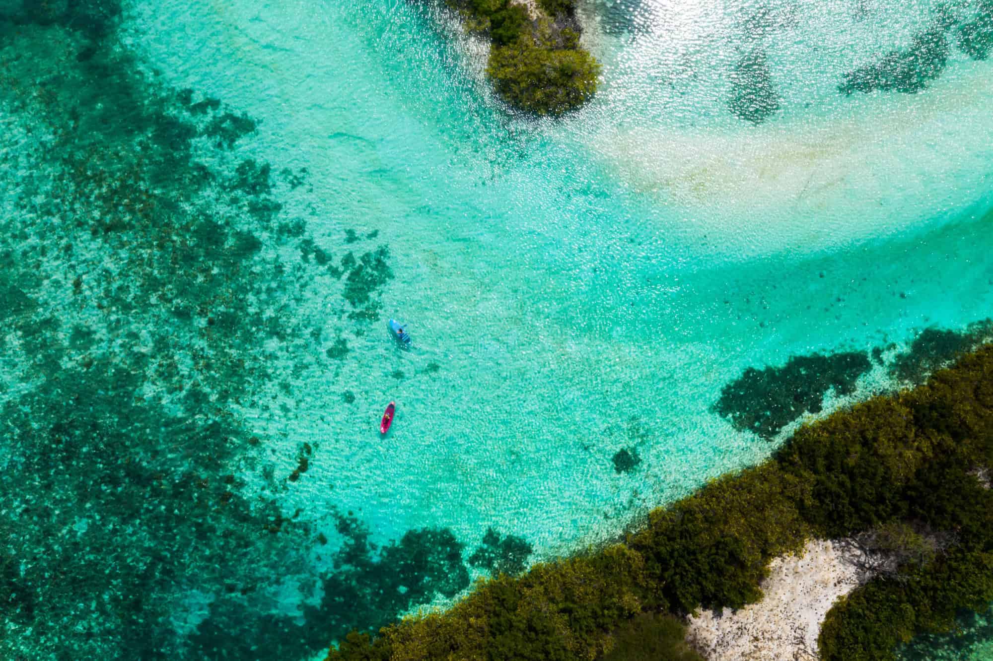 Aerial view of paddle boards in shallow turquoise water