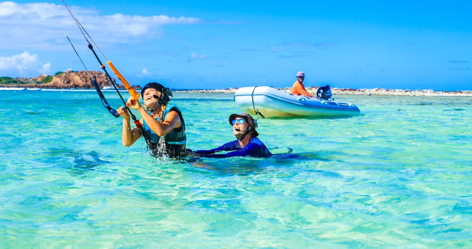 Kitesurf student body dragging behind a kite with private boat support