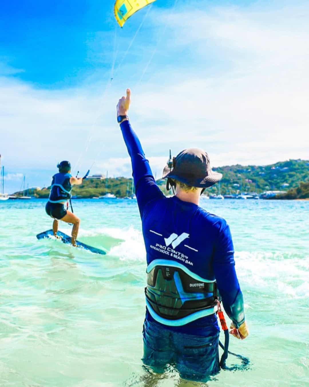 Kitesurf instructor coaching a student during a first water start on Union Island