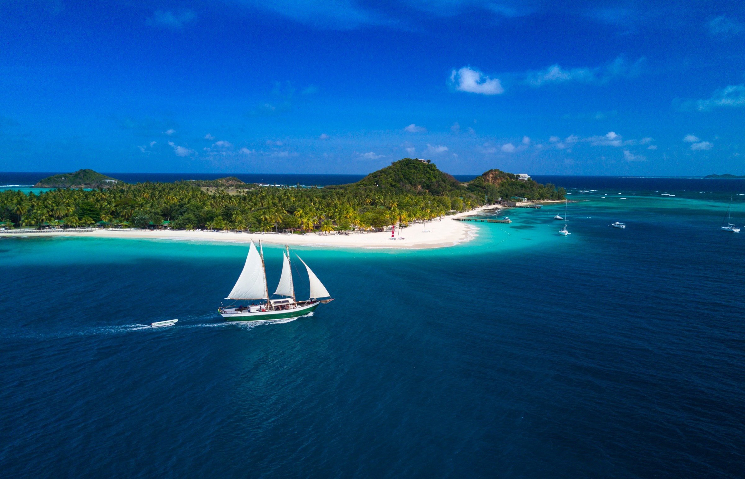 Palm Island in the Grenadines with a schooner in front of the beach